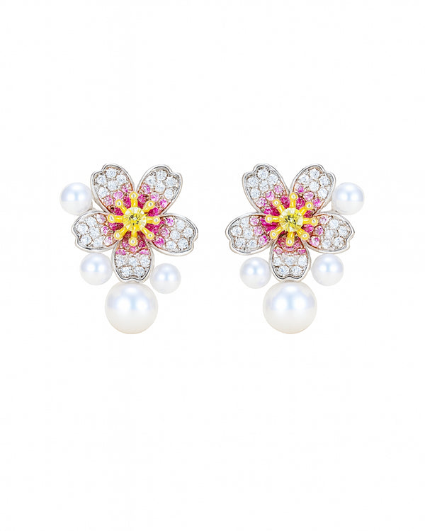 Pair of floral earrings with pearl-like beads on a white background